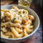 A bowl of creamy garlic parmesan chicken pasta, topped with shredded cheese and parsley, perfect for easy dinner recipes.