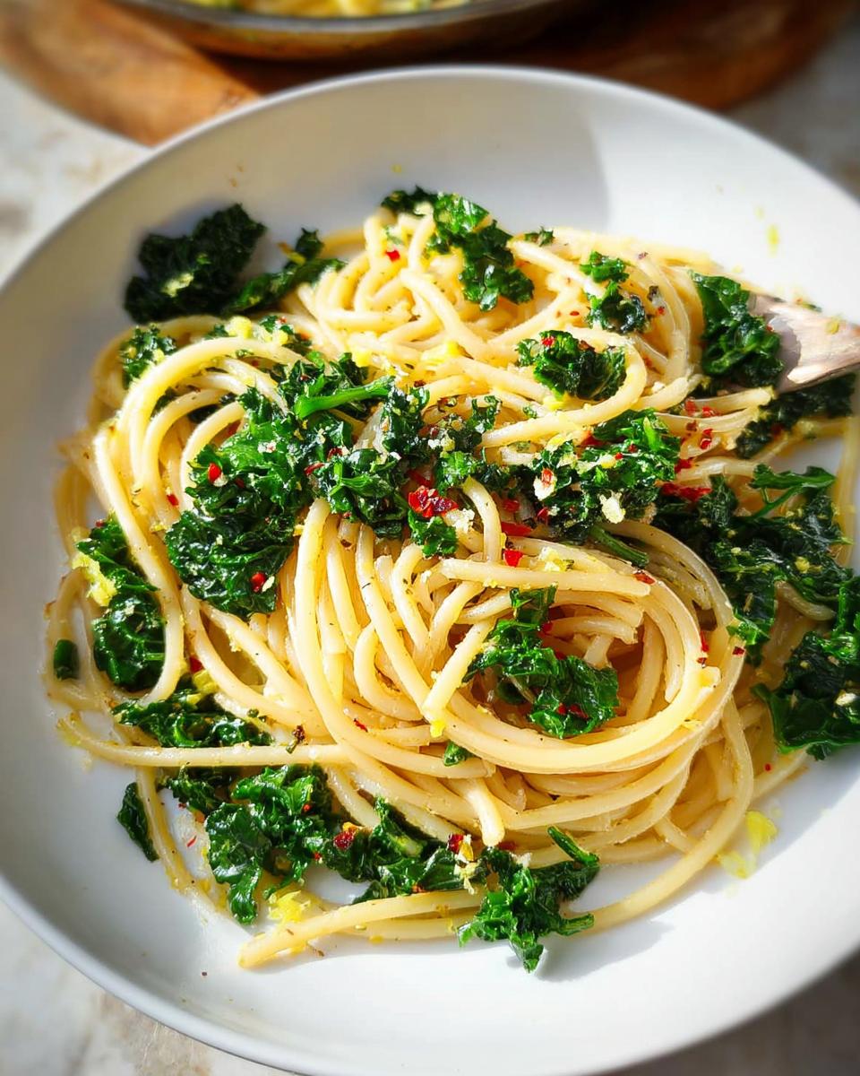 A bowl of spaghetti tossed with vibrant green kale and red pepper flakes, perfect for easy dinner recipes.